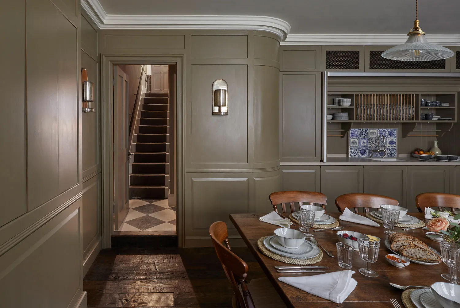 Panelled kitchen and dining room with staircase beyond
