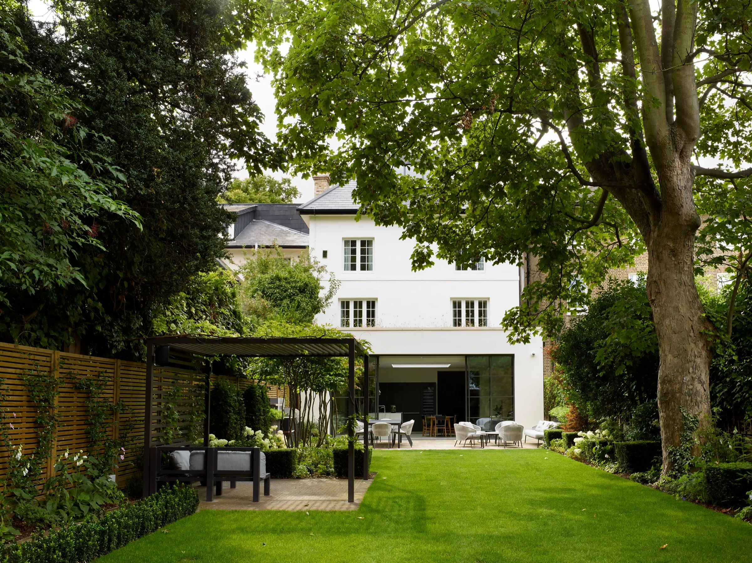 Rear garden with pergola and the extended house beyond