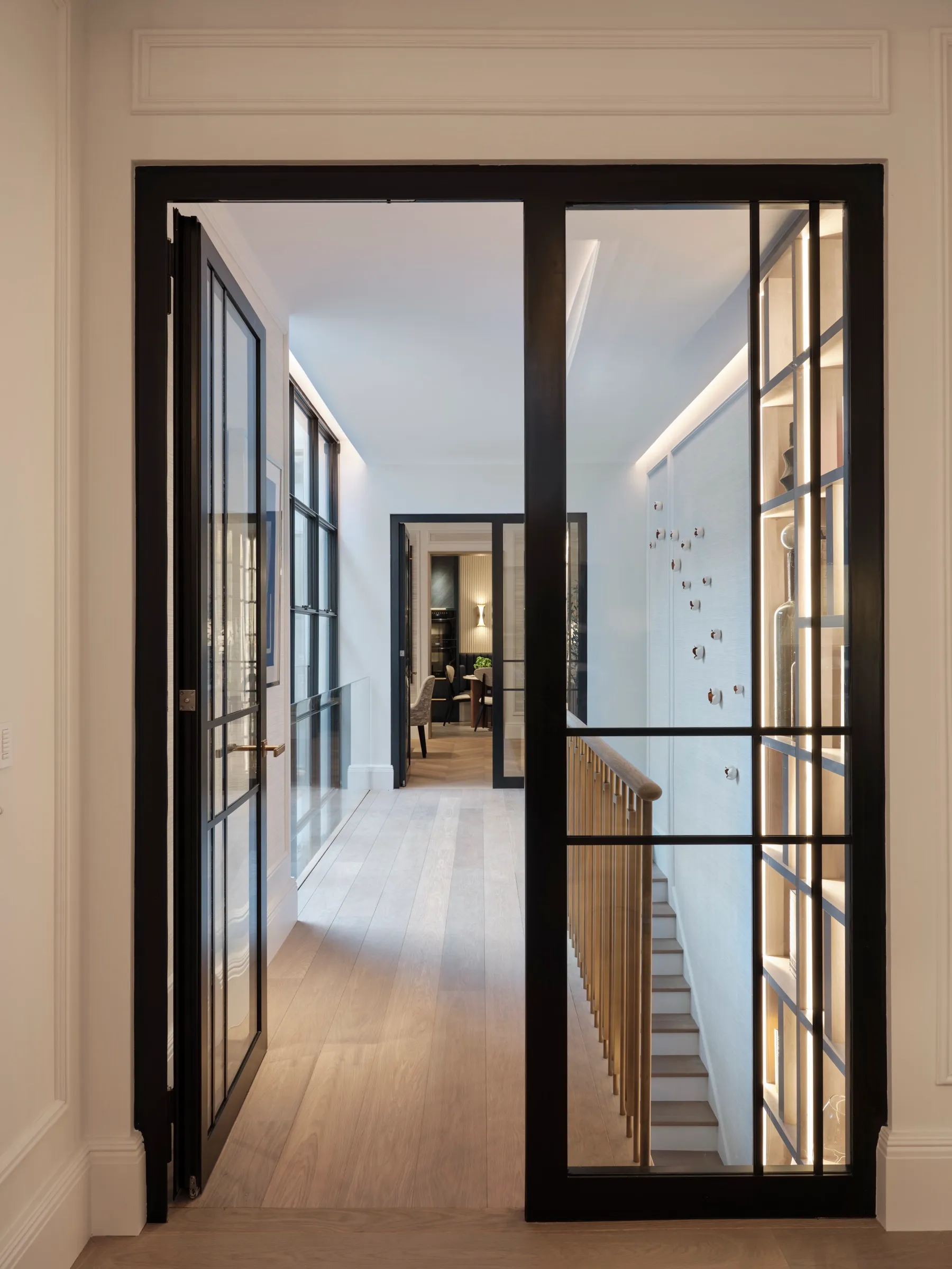 Black steel-framed double doors opening onto a hallway
