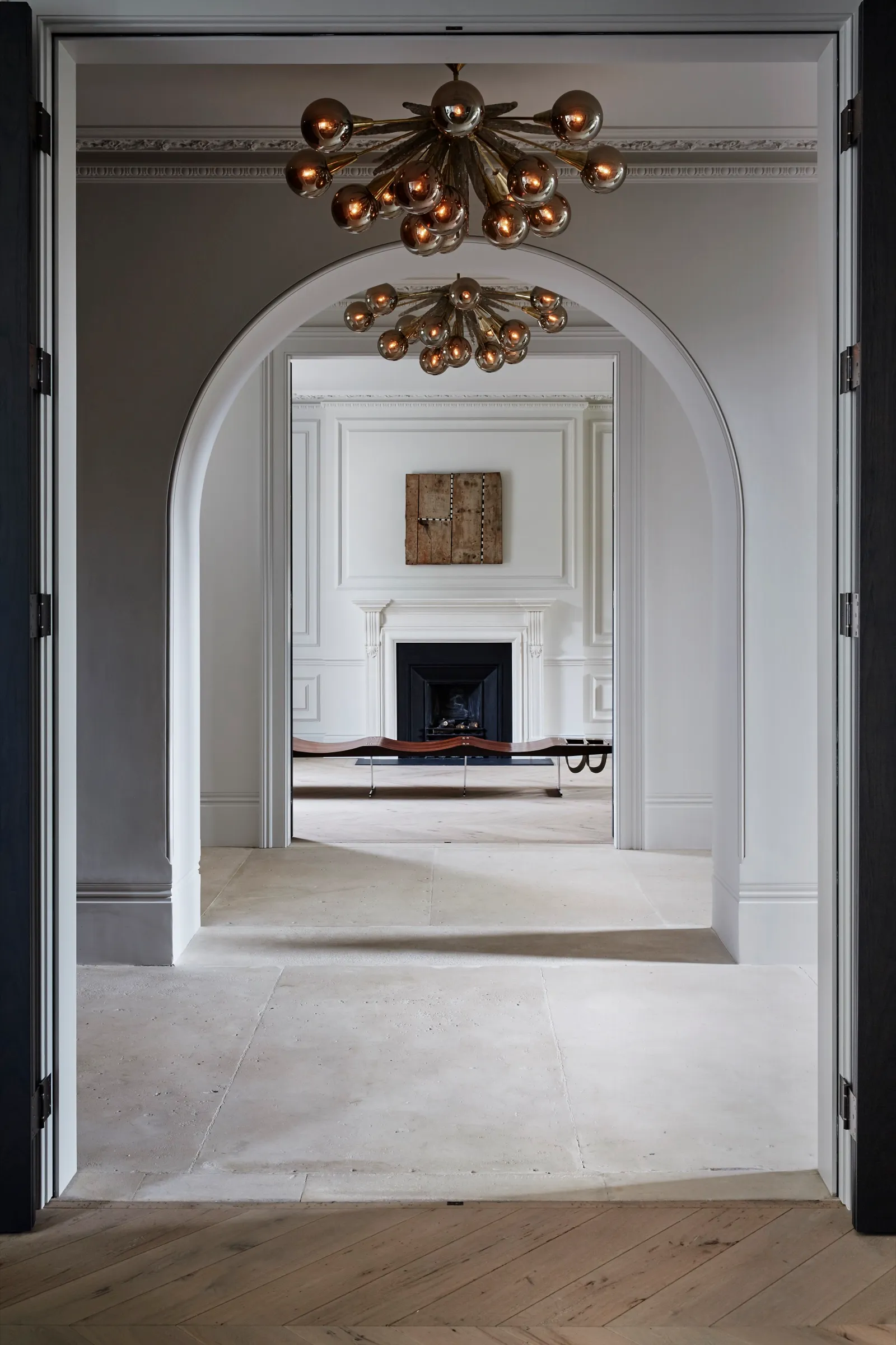 Enfilade through an arched doorway to a fireplace