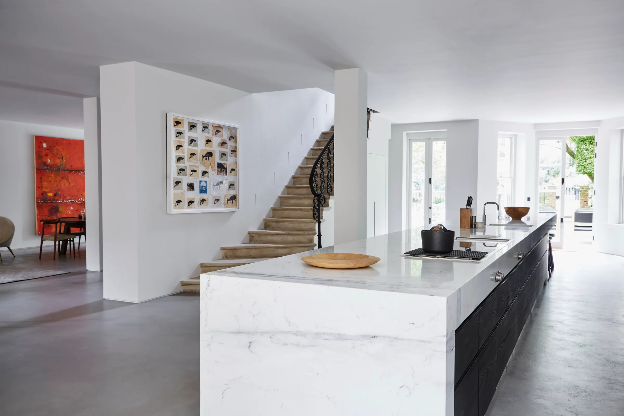 Open-plan kitchen with marble island and stone staircase