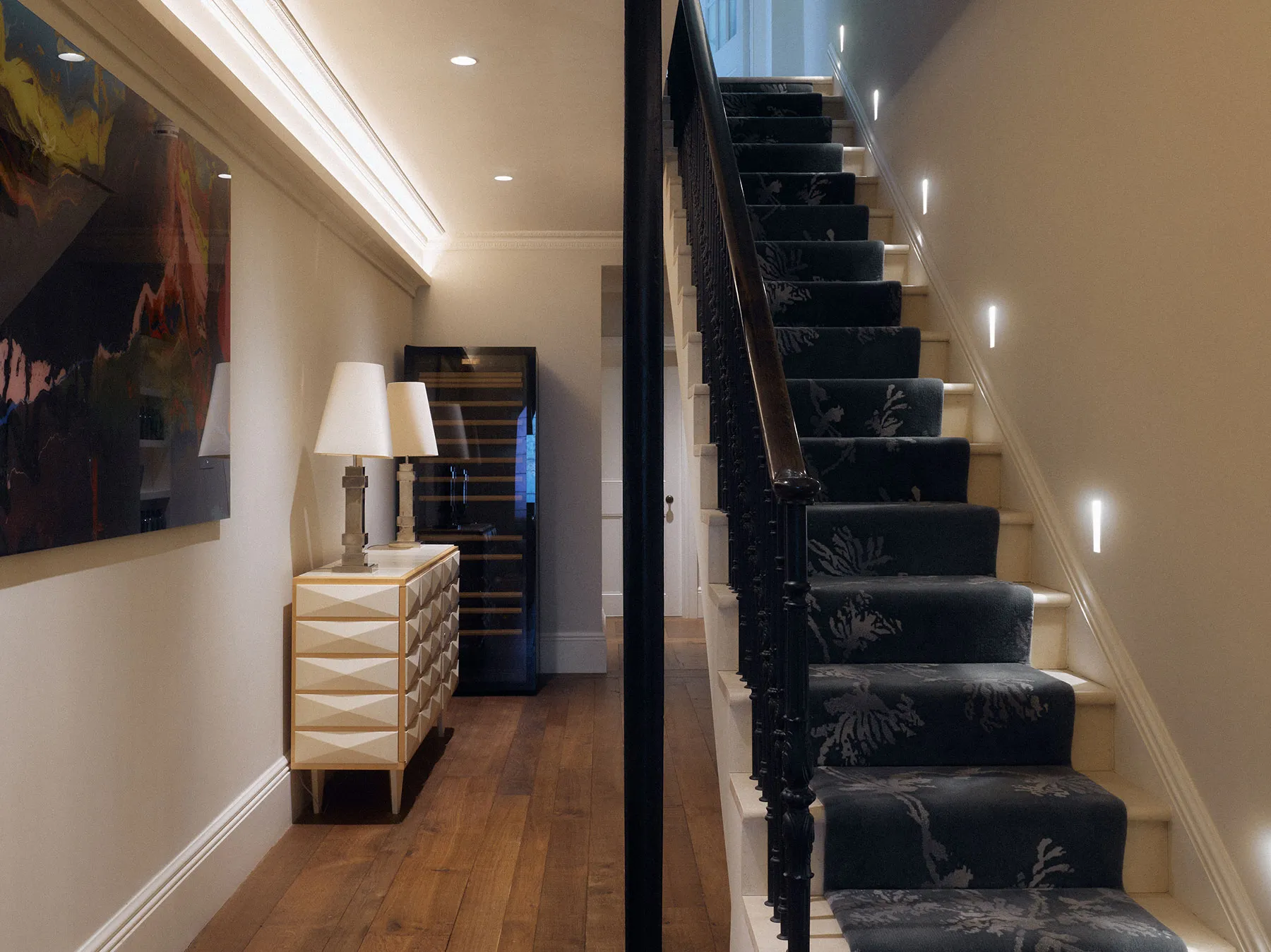 Lit staircase with dark balustrade and runner