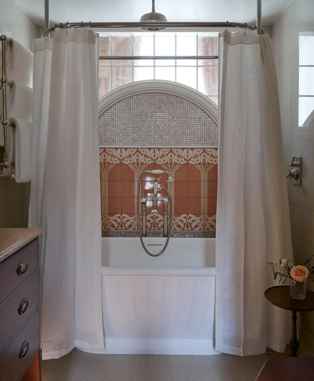 Bathroom with arched window and curtained bath