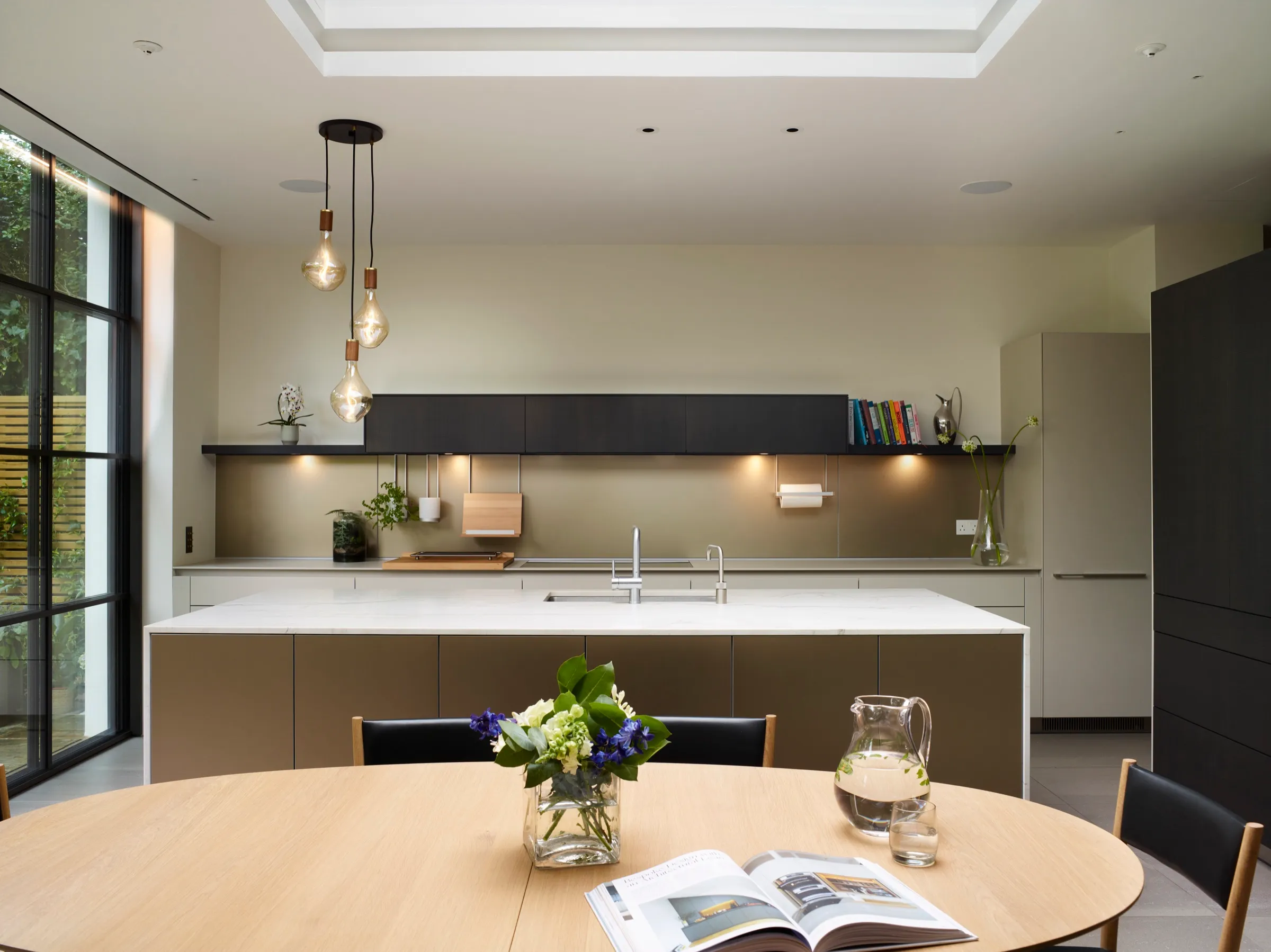 Kitchen with bronze-toned island and lit display shelf