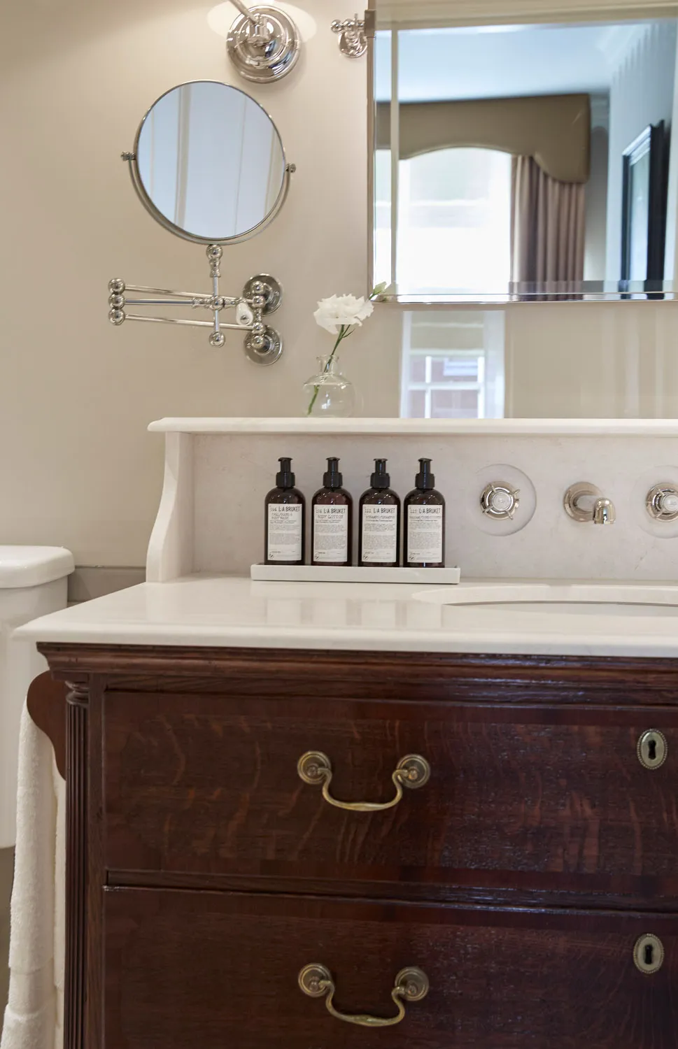 Bathroom with marble-topped antique chest vanity