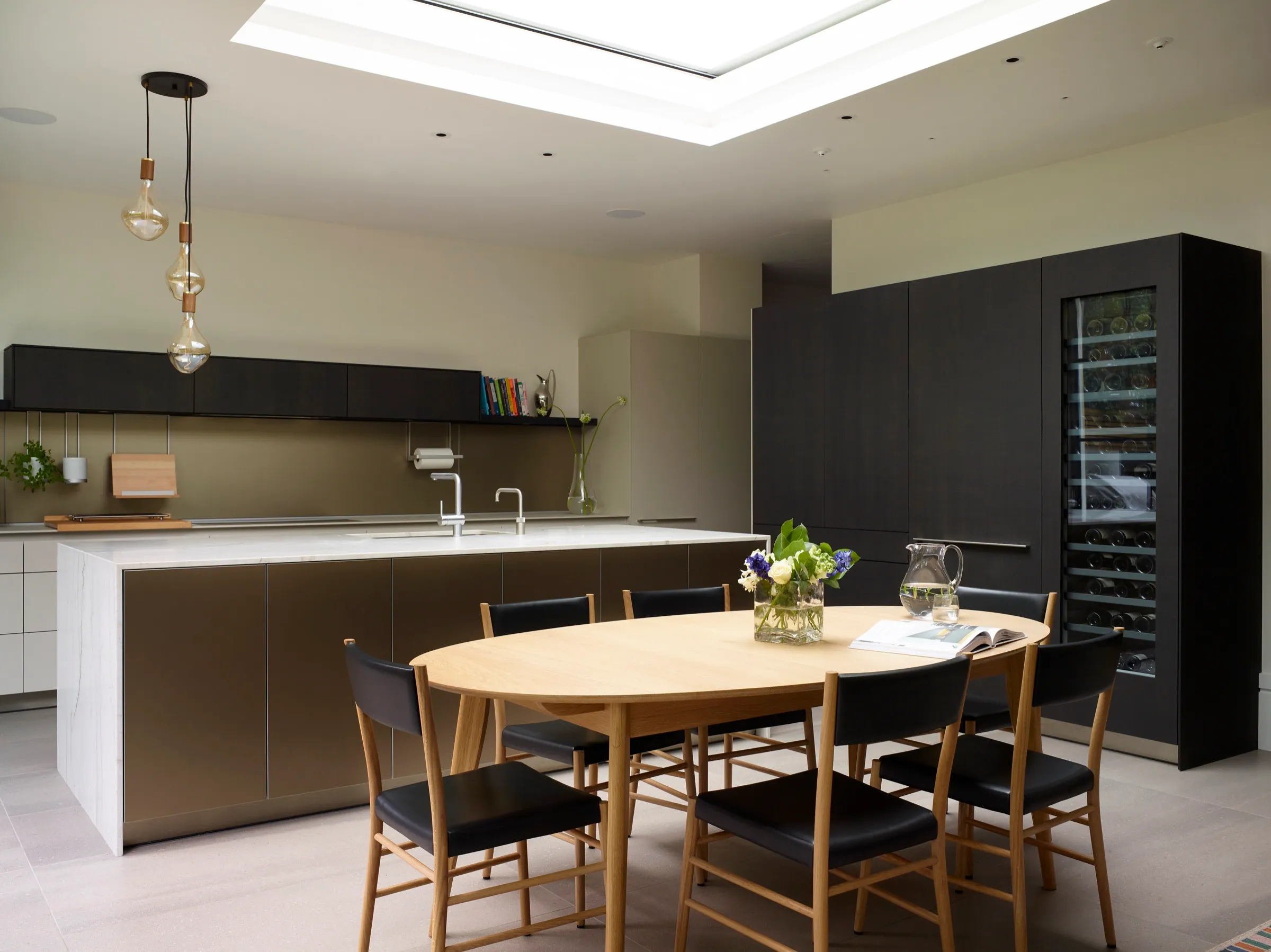 Kitchen and dining area with tall dark cabinetry and wine storage