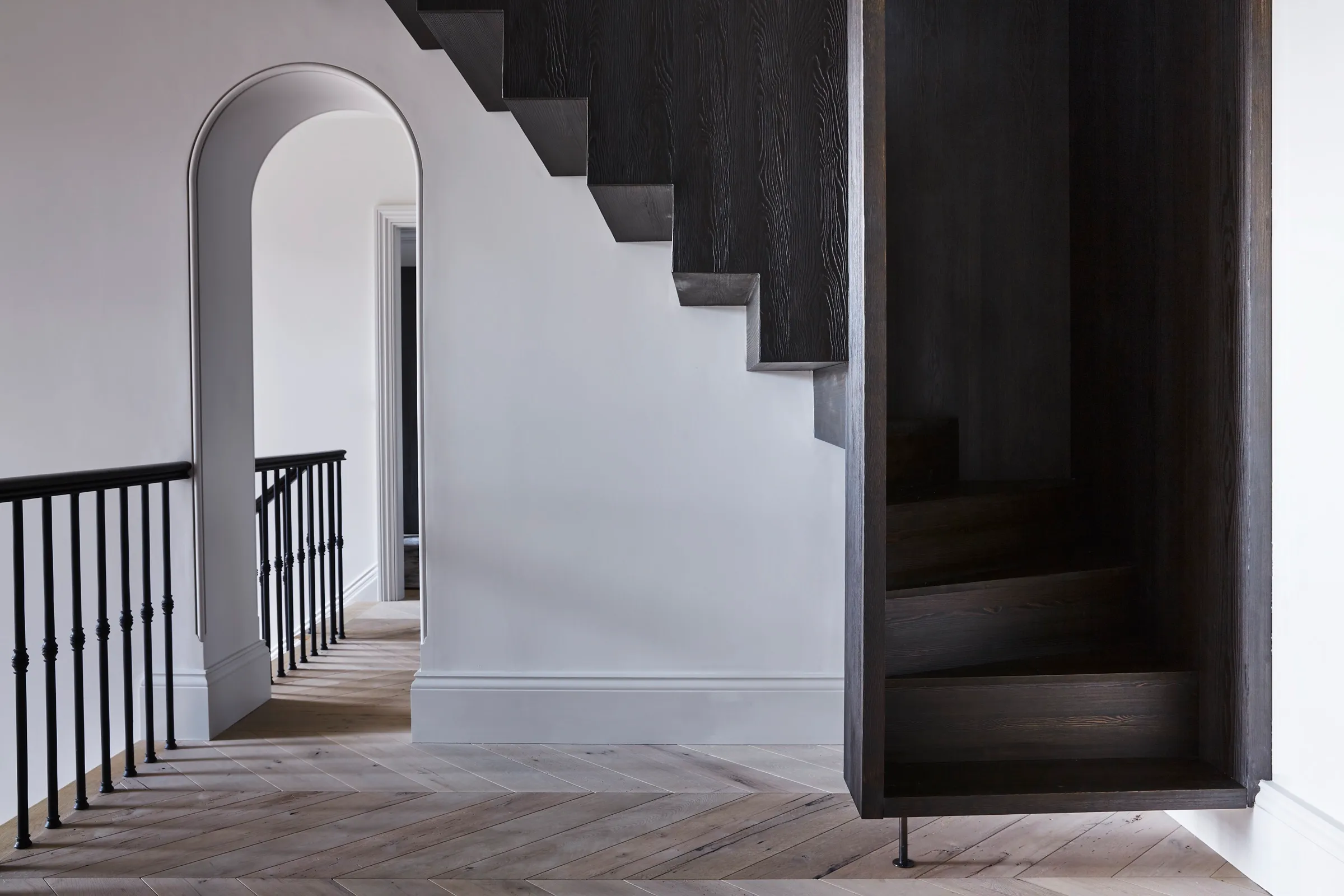Arched opening beside a dark timber staircase