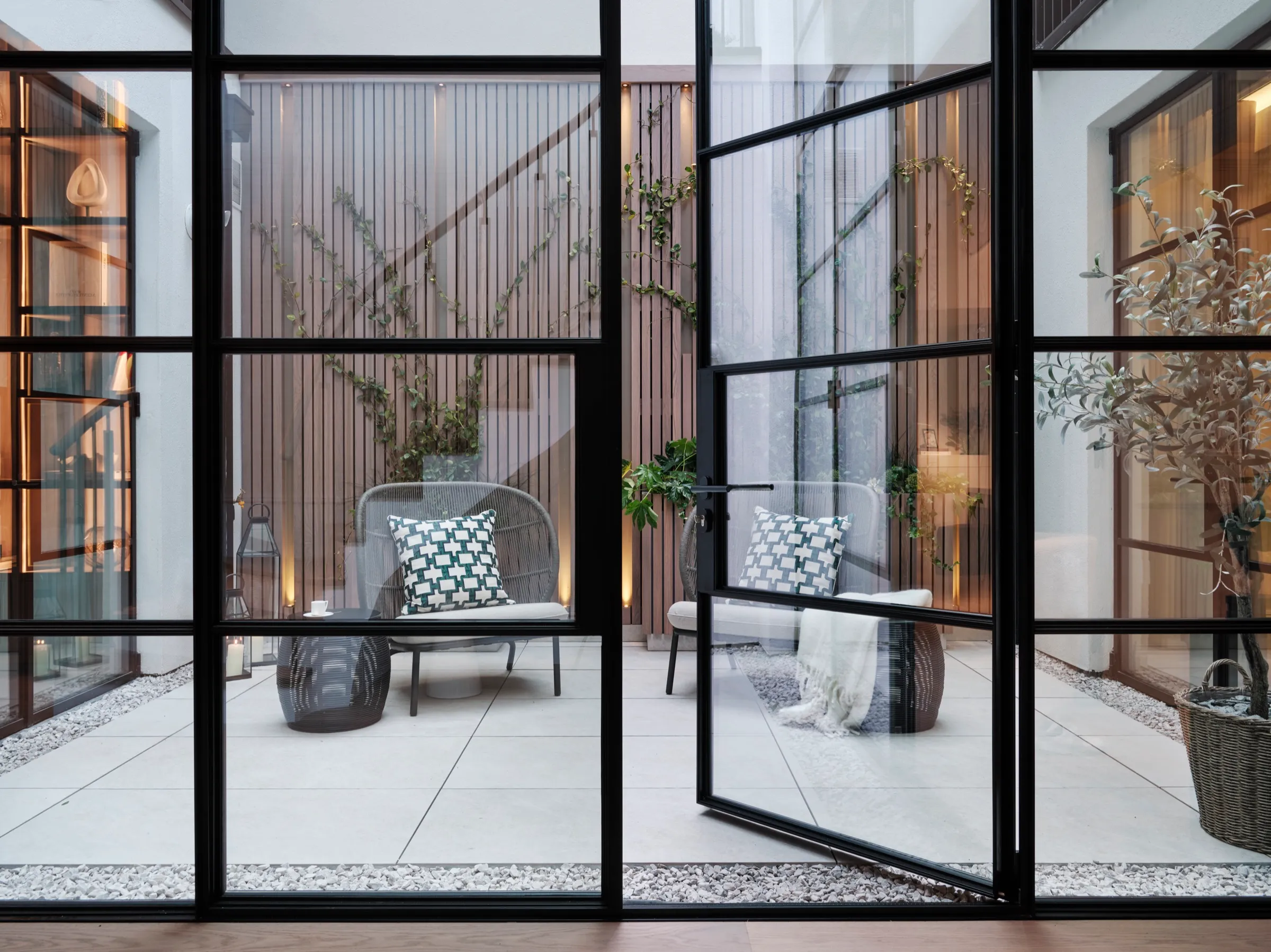 Courtyard with fluted timber cladding seen through steel-framed glazing