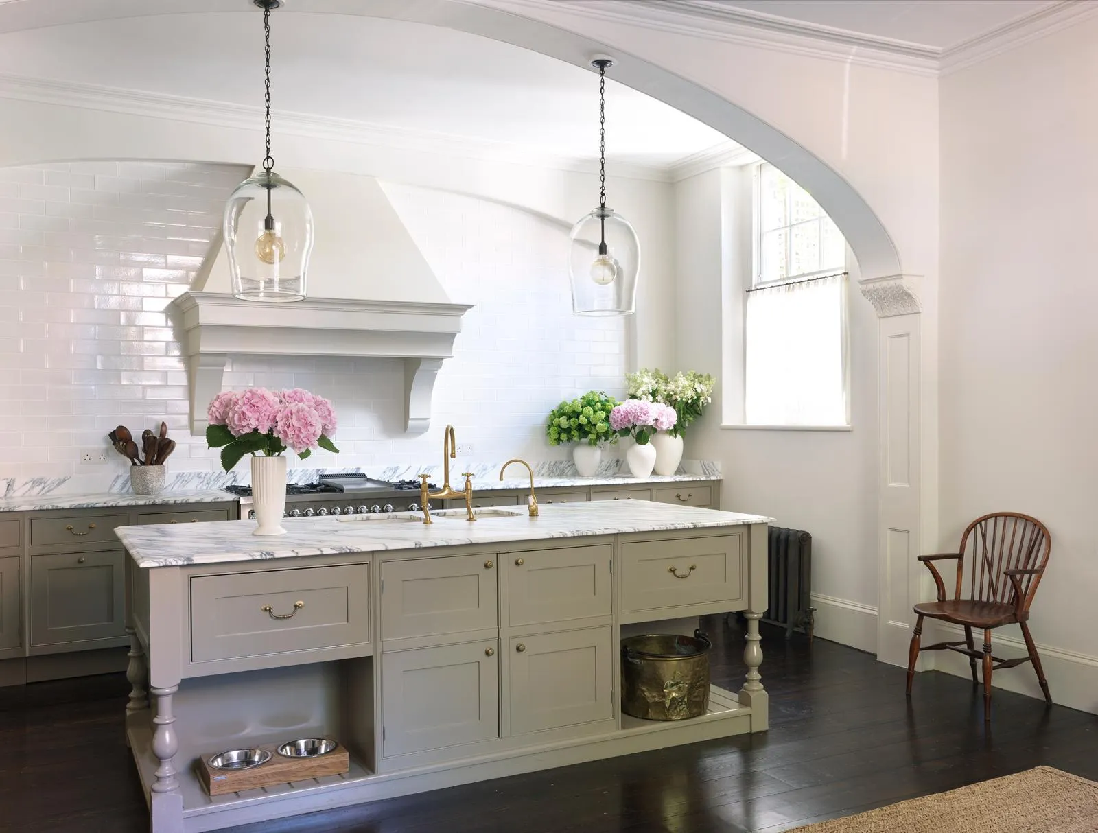 Kitchen with painted island beneath an arched opening