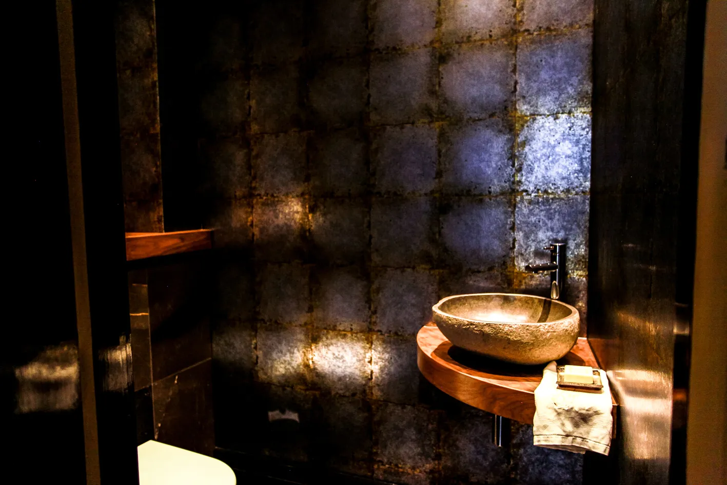 Cloakroom with metallic wallcovering and stone basin