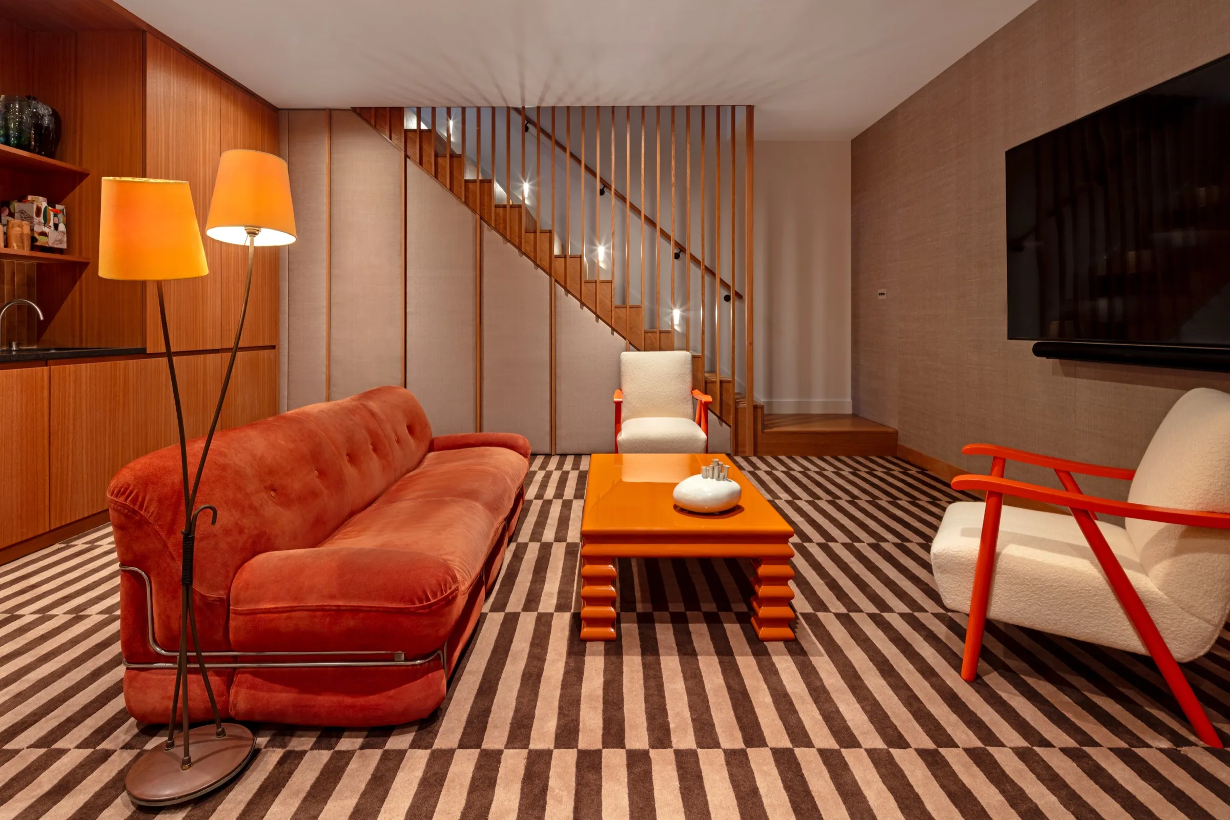 Lower-ground living room with timber panelling and staircase