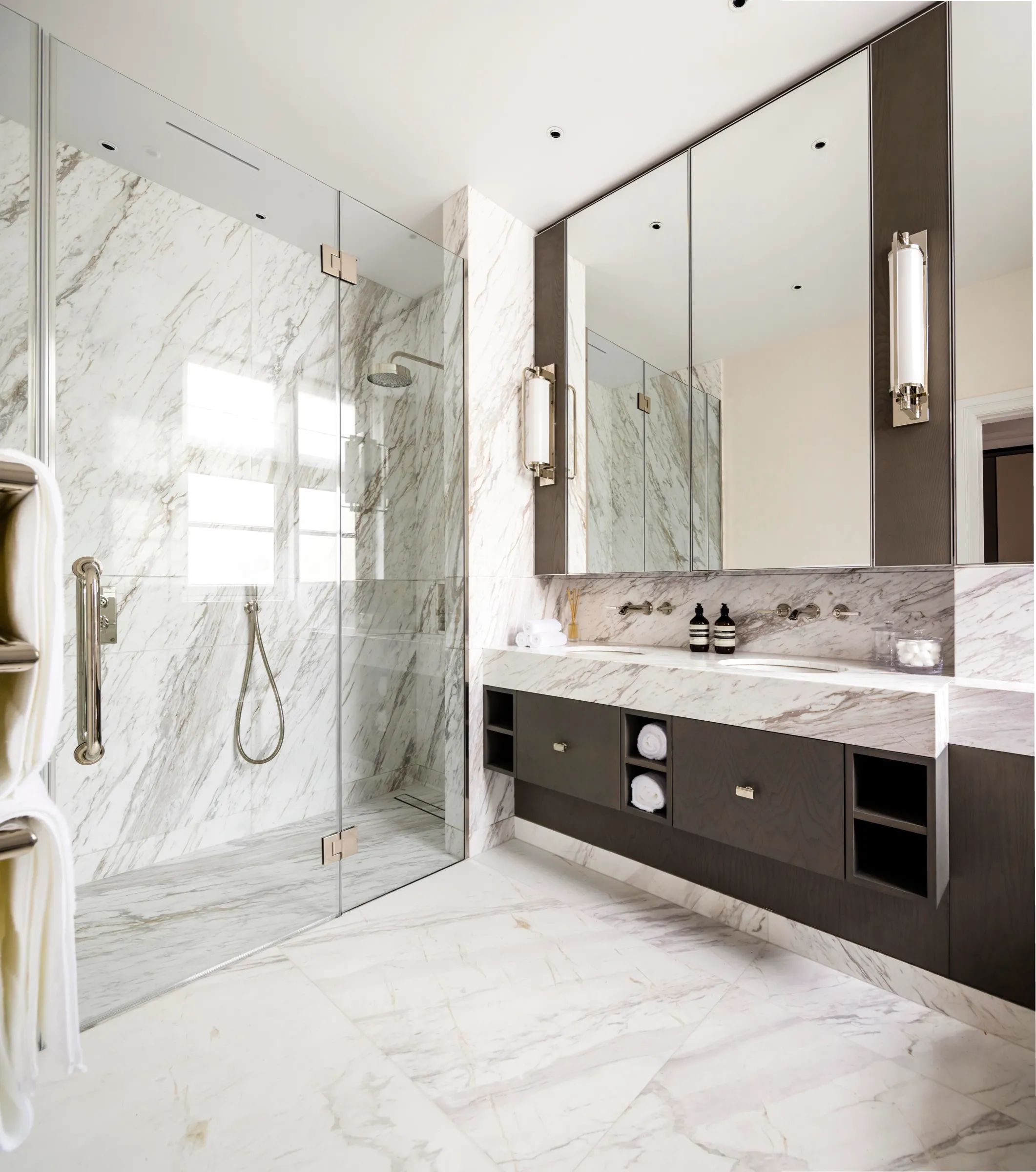 Marble bathroom with walk-in shower and dark vanity