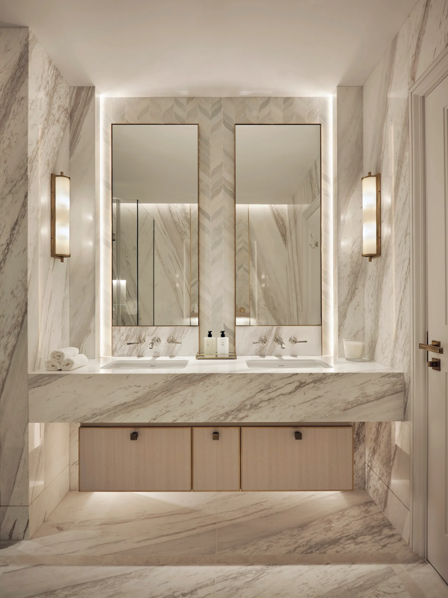 Marble bathroom with double vanity and backlit mirrors