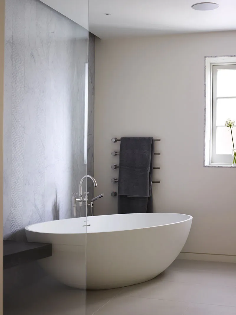 Bathroom with freestanding bath and stone wall