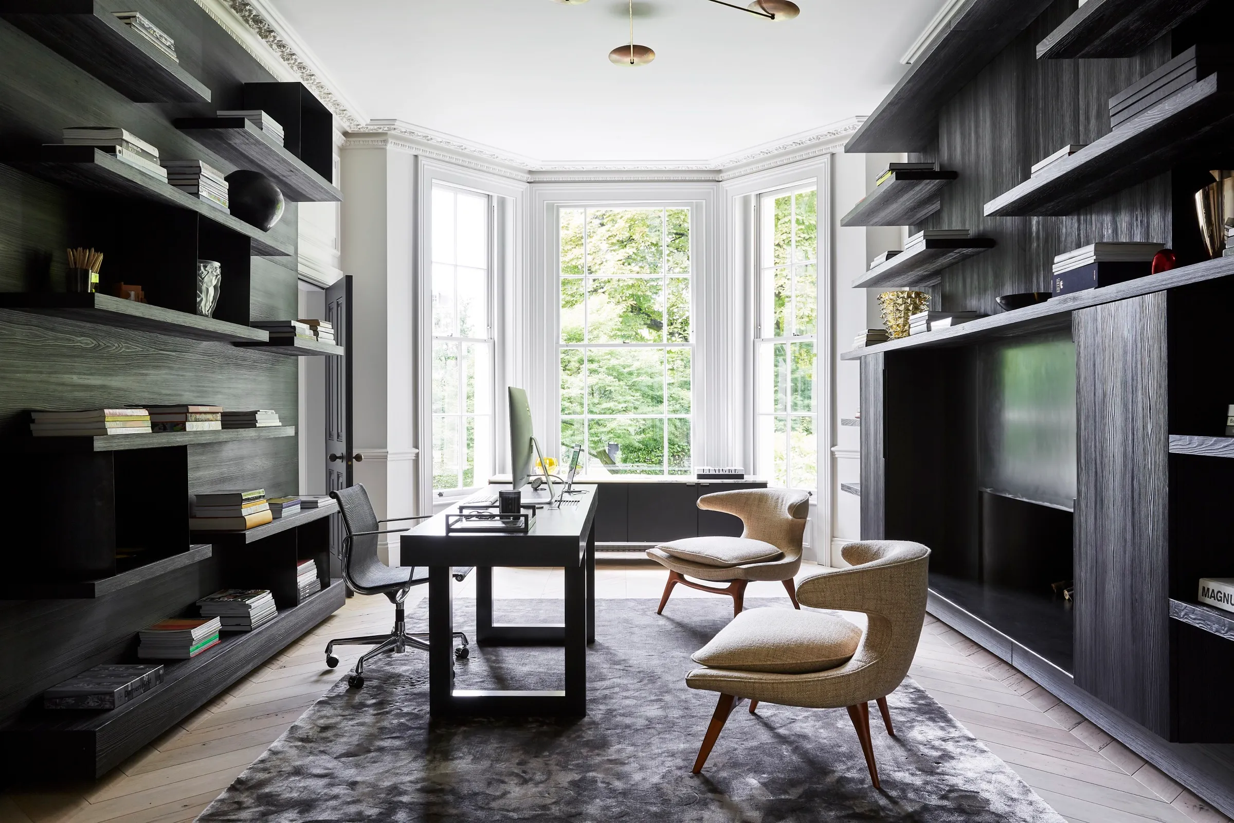 Study with dark timber shelving and bay window